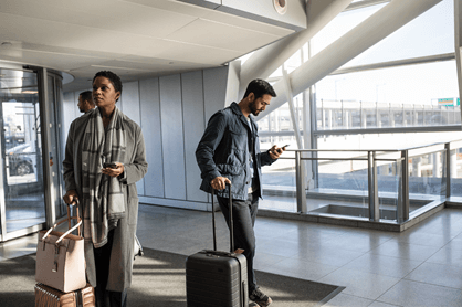A picture of people in an airport using mobile devices.