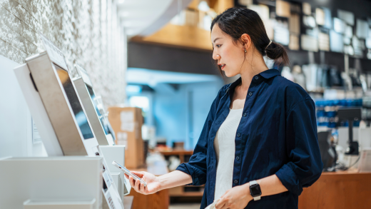 Two women compare devices in a retail store.
